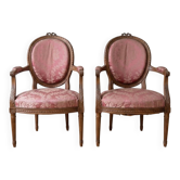 Pair of Louis XVI medallion armchairs in wood and pink fabric.