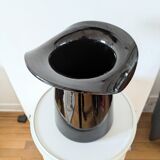 Large black glass vase topped with a 70s hat