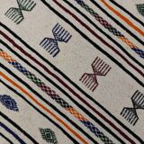 White carpet with multicolored Berber patterns woven hands