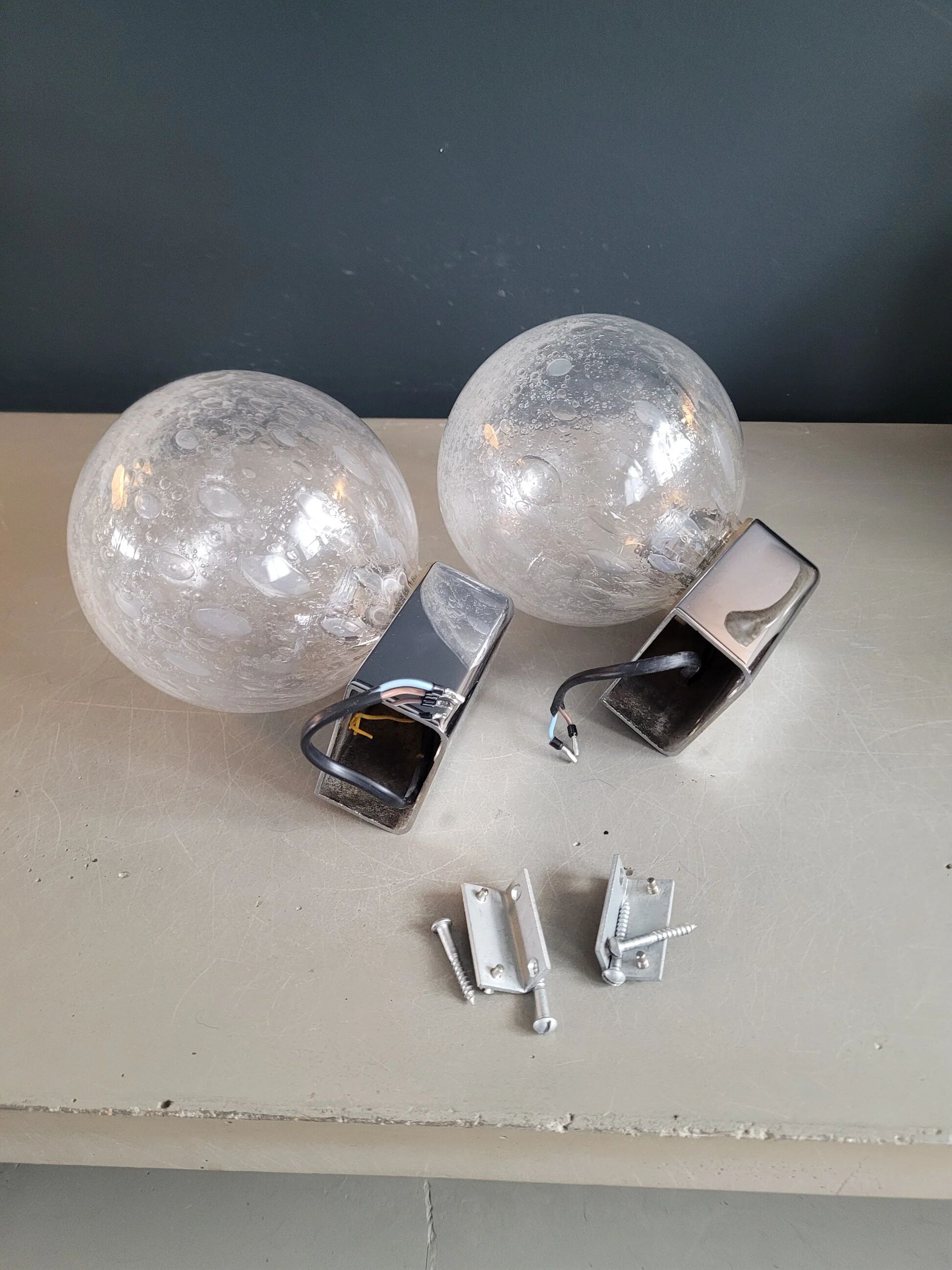 Pair of vintage wall lights in chrome metal with bubbled glass globes.