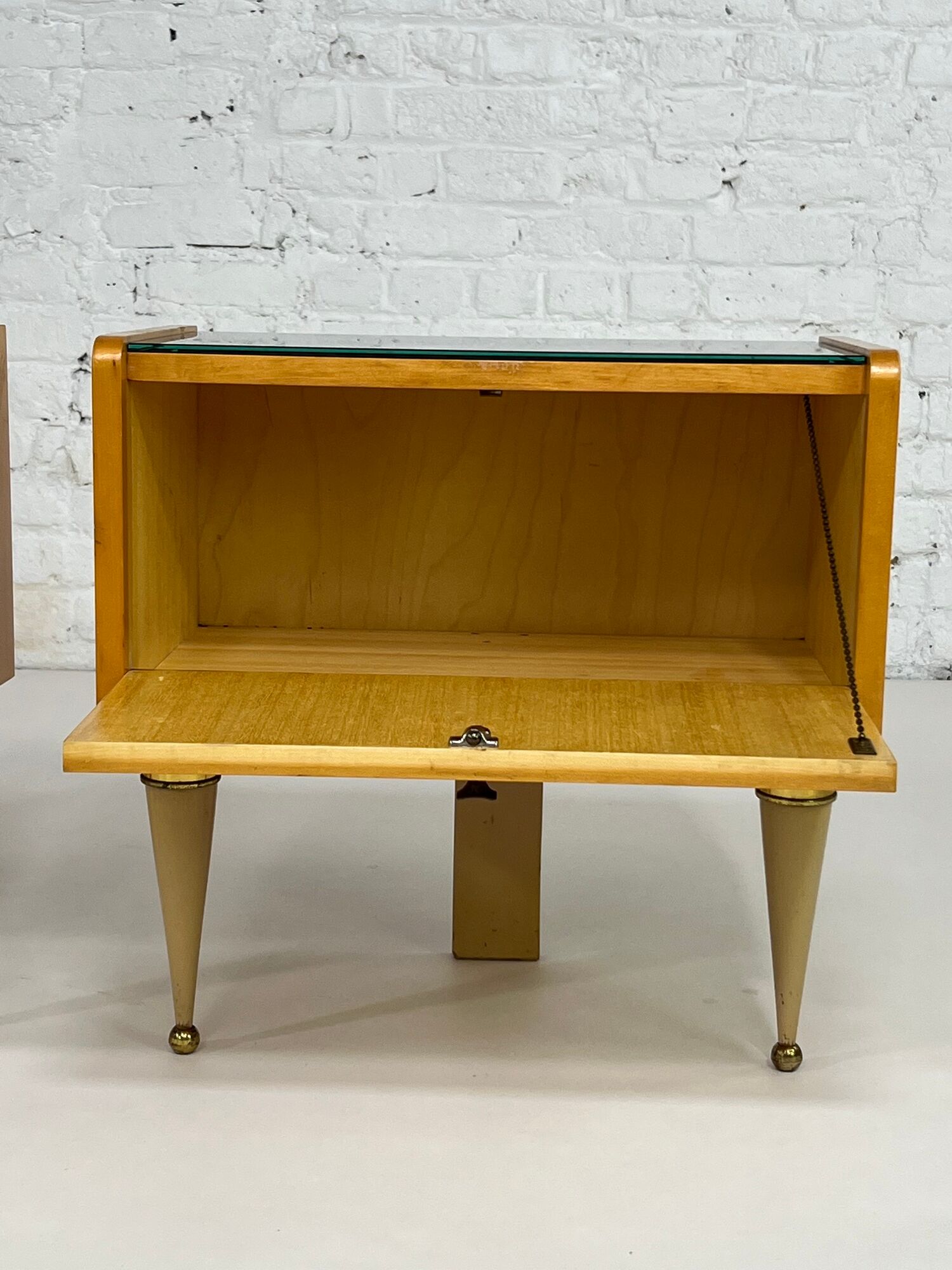 Pair of bedside tables in wood, brass and black glass top