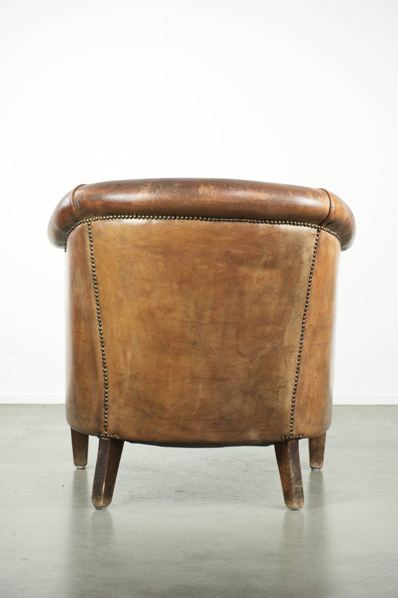 Vintage sheepskin club armchair finished with decorative nails