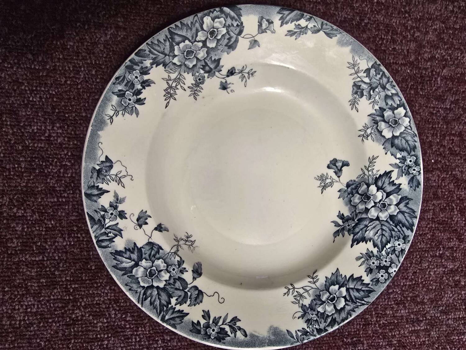 Many deep plates in old faience, blue tone.