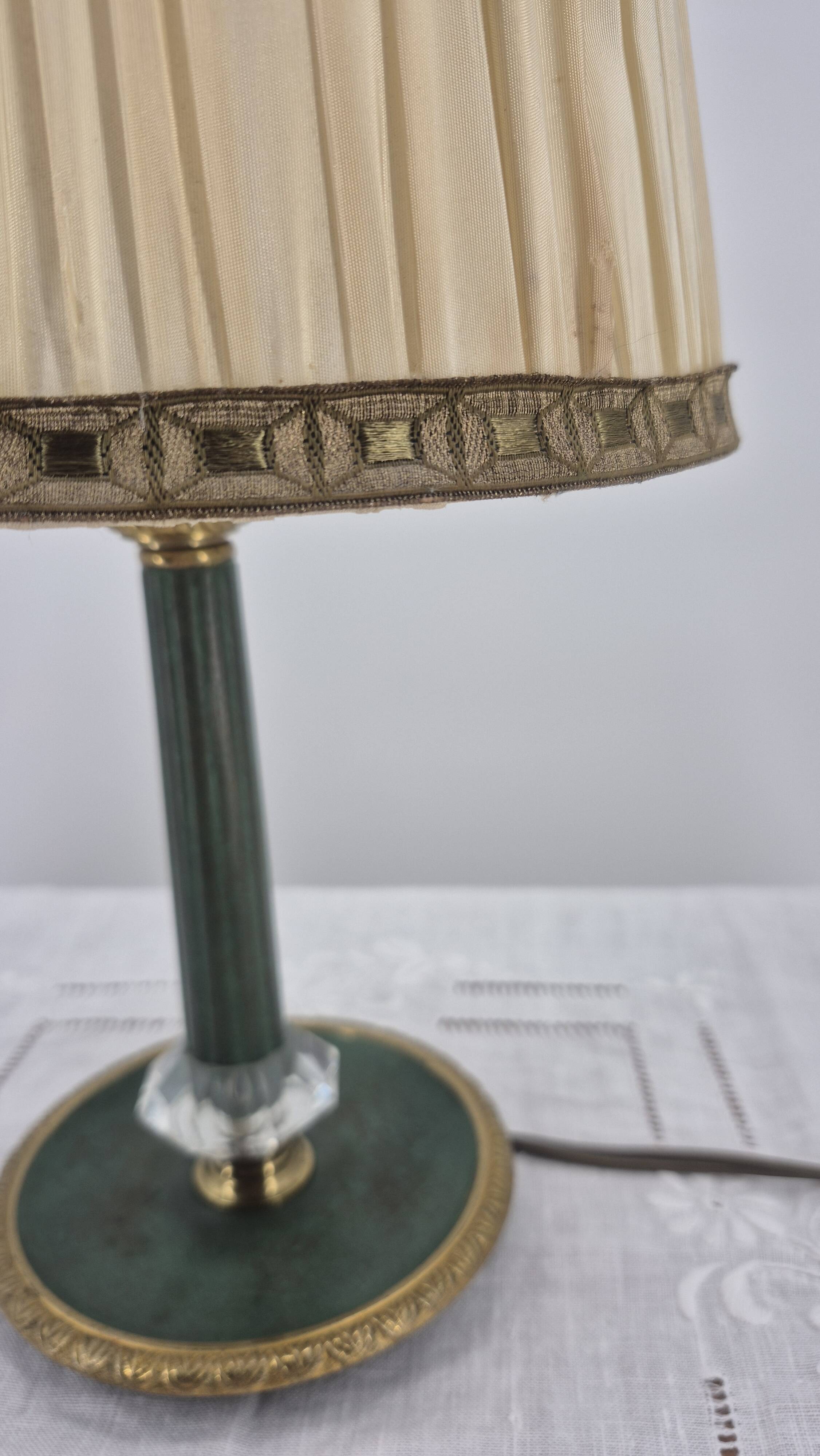 Brass table lamp with green patina and empire-style fabric shade.