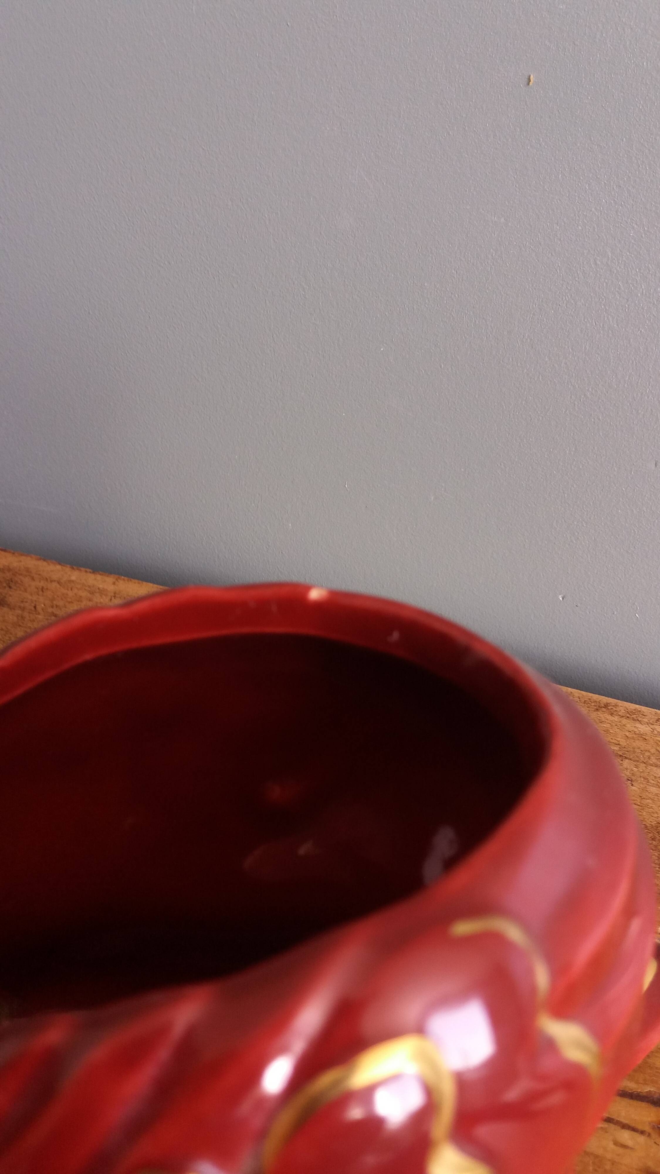 Poet Laval swan hides zoomorphic pot in burgundy ceramic.
