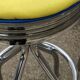 Set of 5 vintage swivel bar stools in blue, red, orange, and yellow.