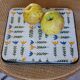 Vintage laminated wooden trivet with yellow, green, and blue flowers
