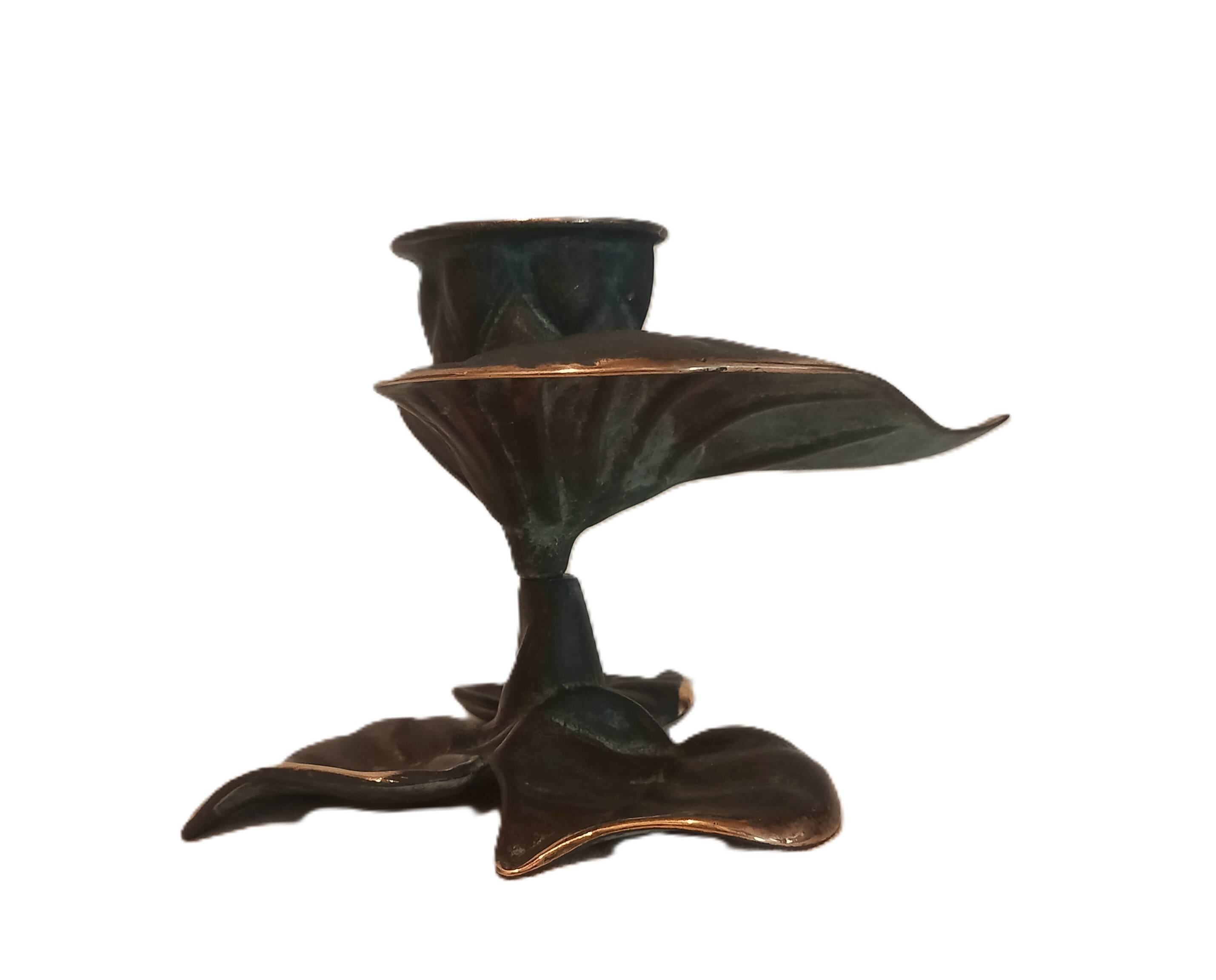 Patinated green brass candlestick with foliage decoration.