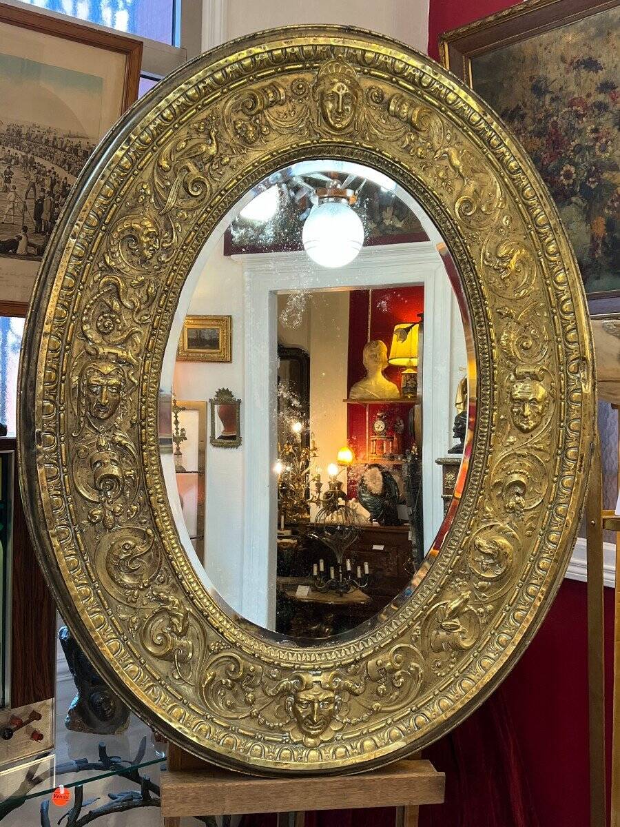 A. Arens, Antwerp, important oval mirror in repoussé brass with numerous animal decorations
