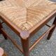 4 dining or kitchen chairs made of solid wood with rush seats.