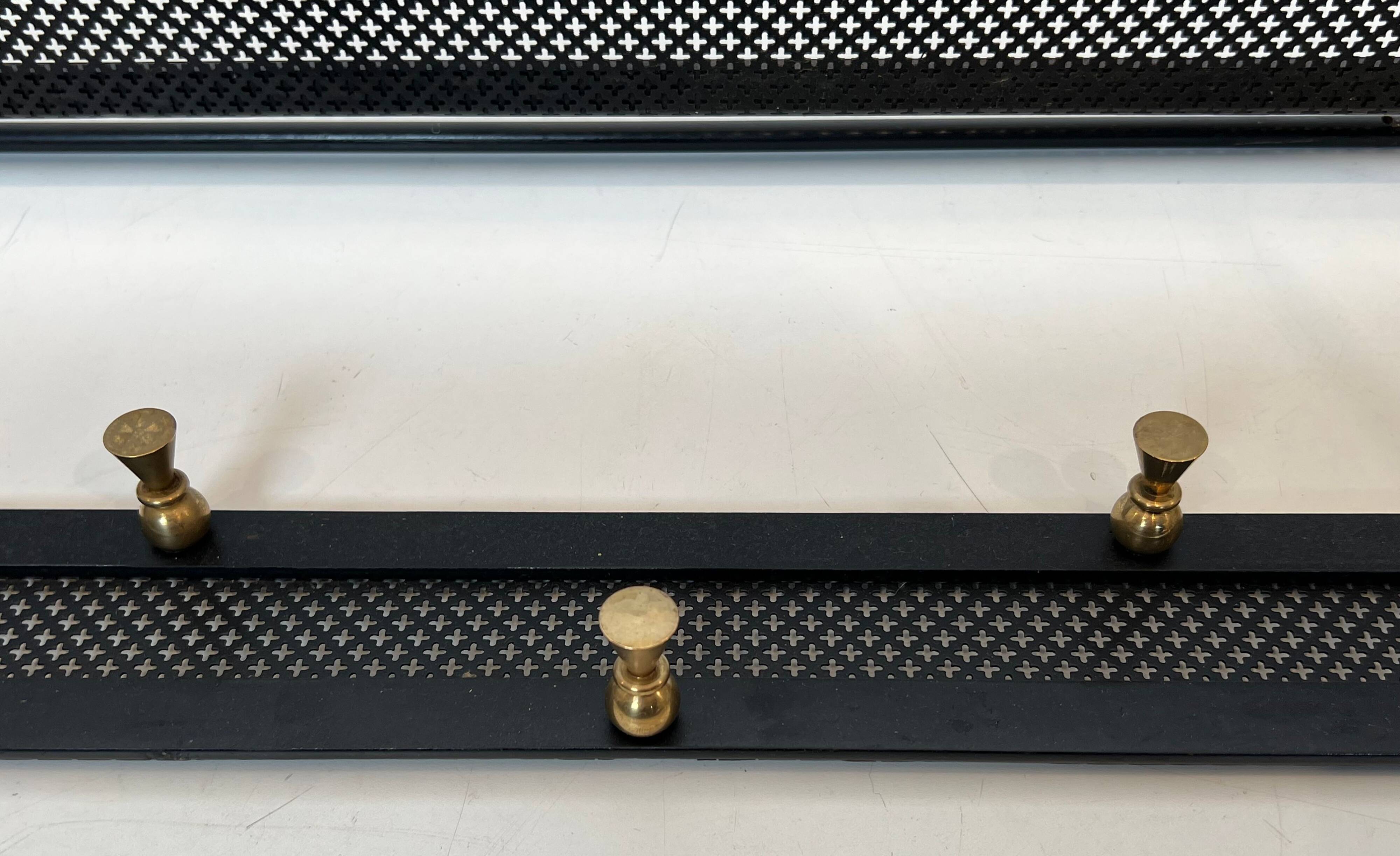 Coat rack in black lacquered metal, perforated sheet metal and brass in the style of Mathieu Matégot