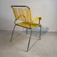 Yellow scoubidou armchair with a chrome tubular frame.