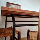 Table with tubular metal legs and wooden top.