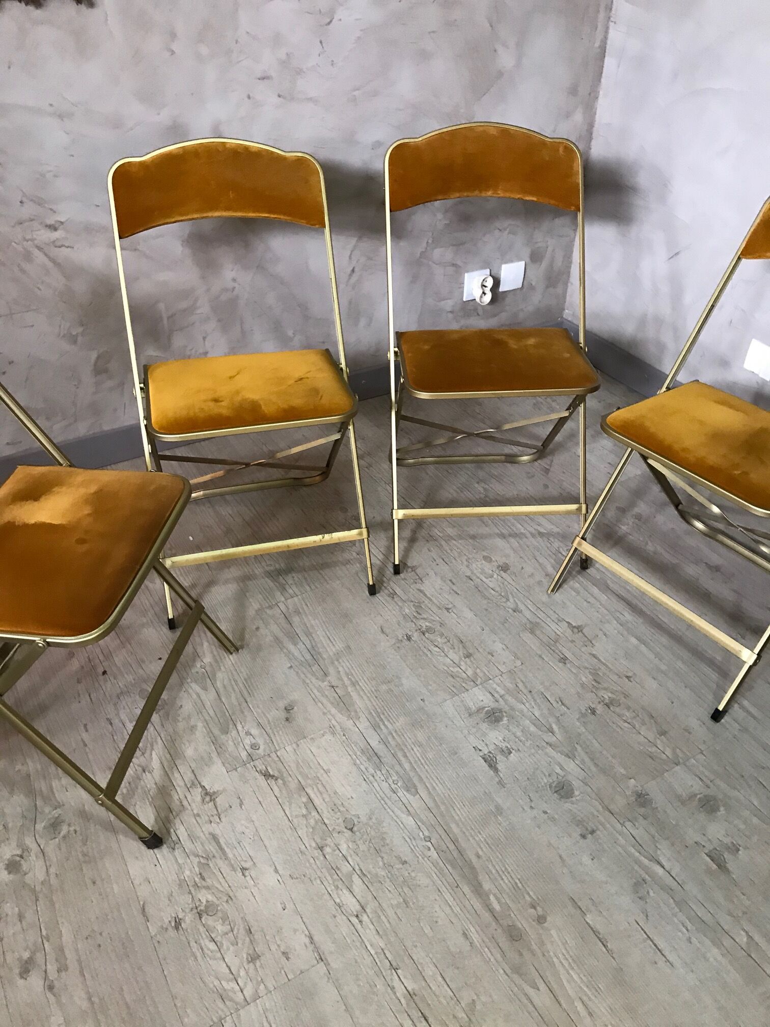 Four folding velvet and brass chairs