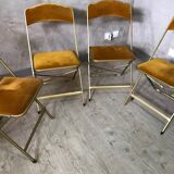 Four folding velvet and brass chairs