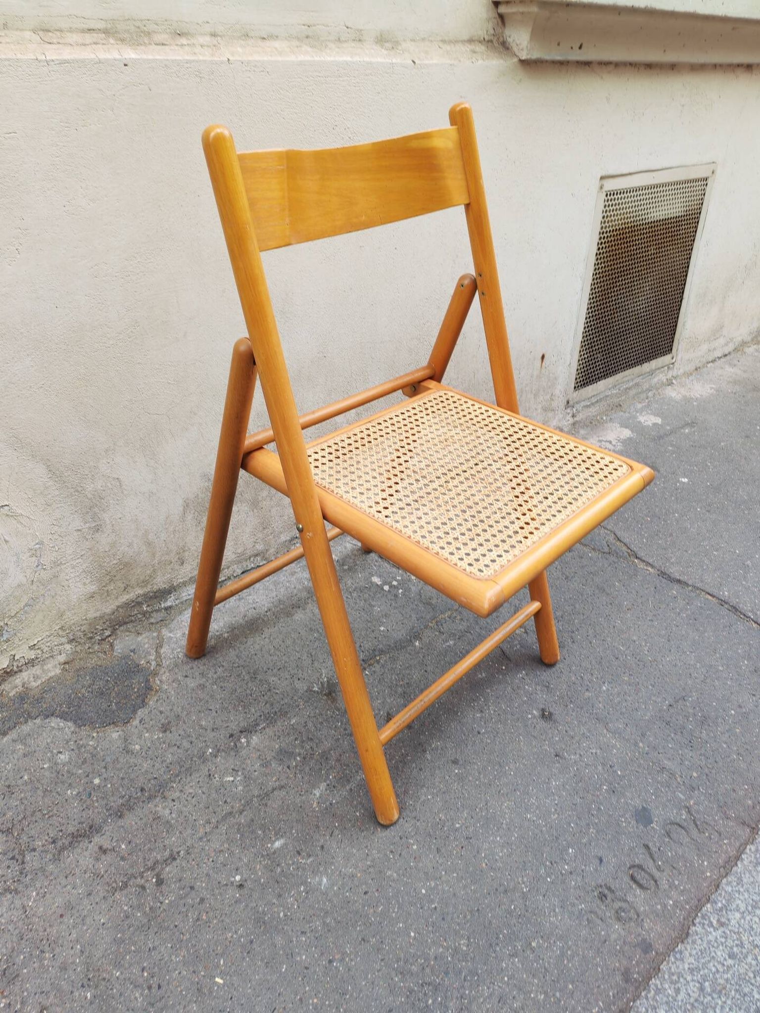 Wooden folding chair with cane from the 1980s.