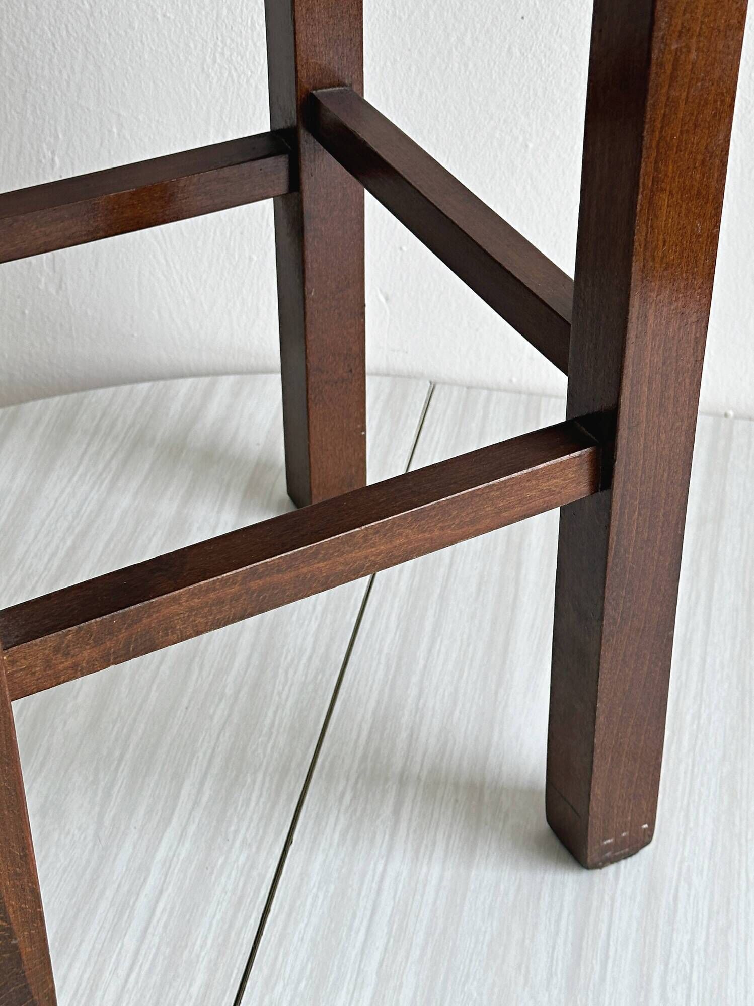 Vintage stool in dark wood with a woven straw seat.