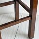 Vintage stool in dark wood with a woven straw seat.