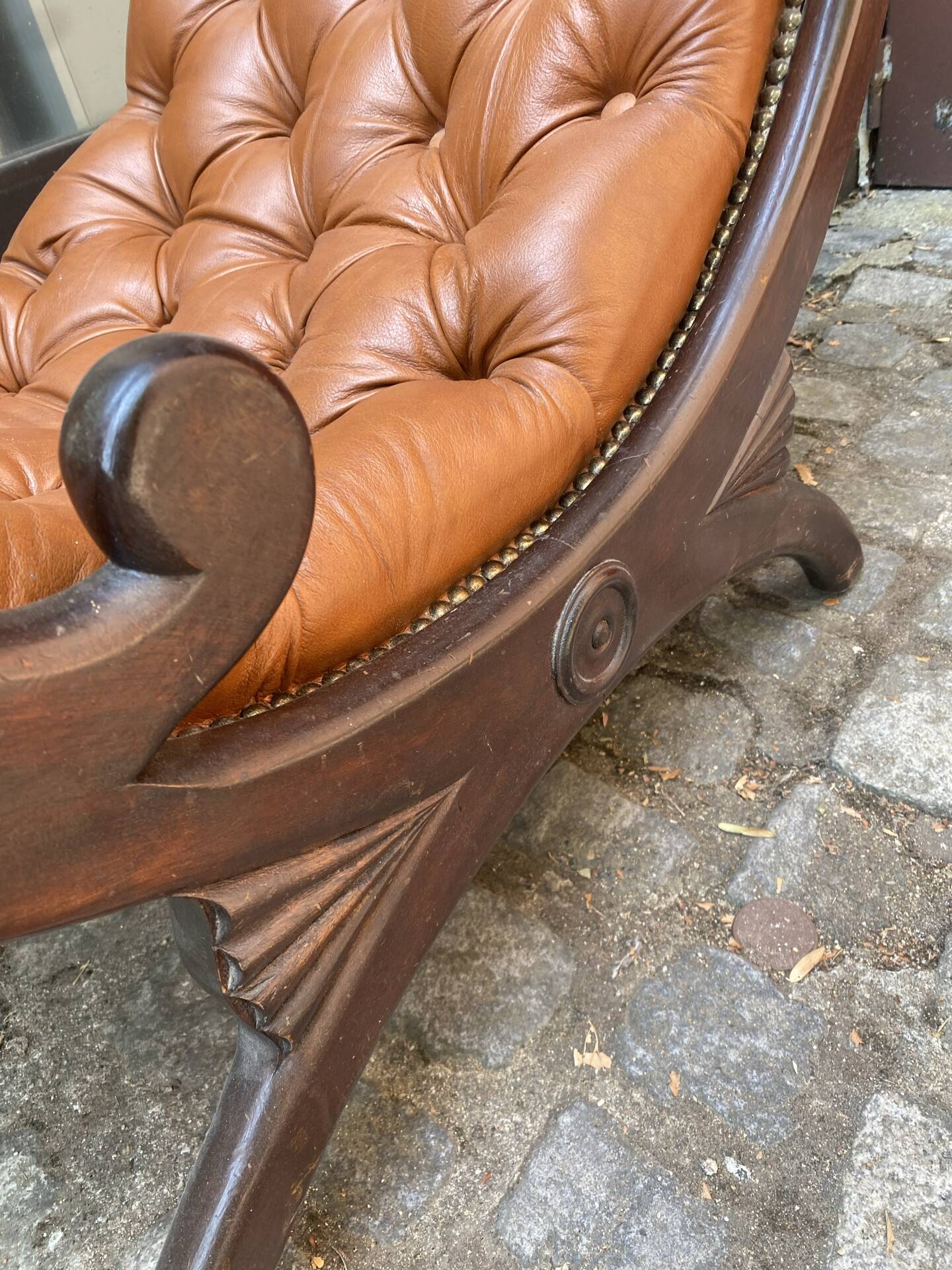 Chesterfield armchair in leather and carved solid wood