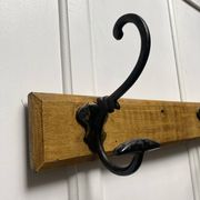 Antique wooden coat rack with metal hooks