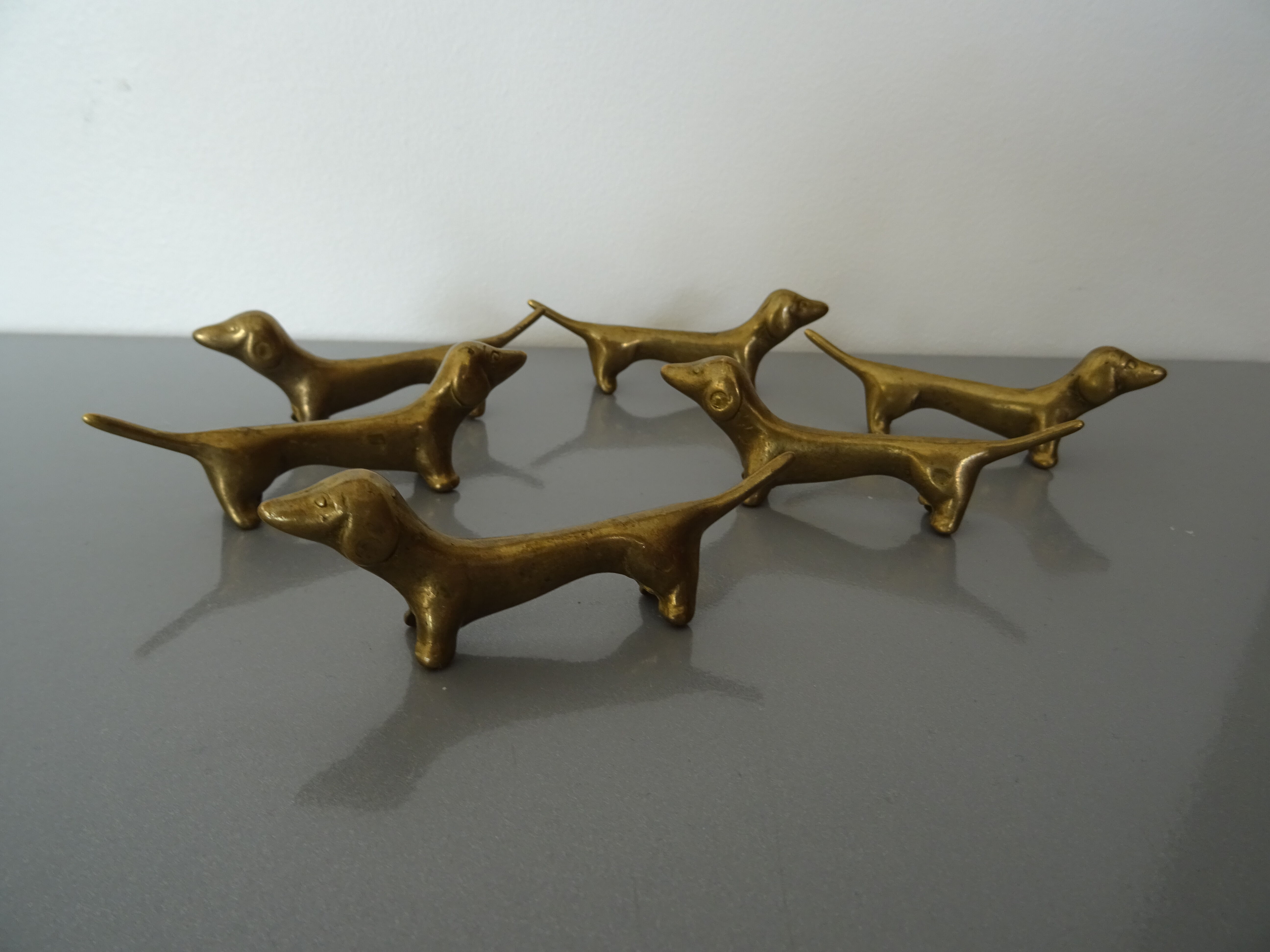 Series of 6 vintage gilded brass dachshund knife holders