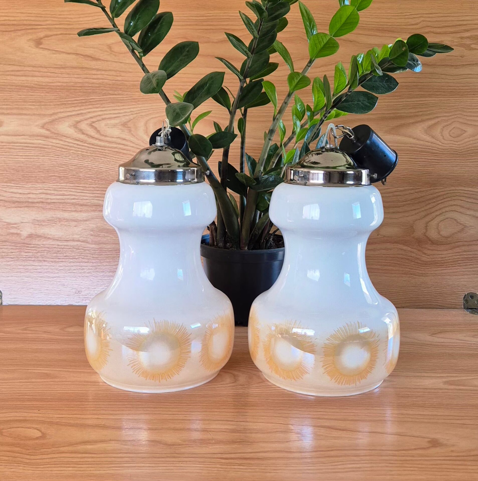 2 vintage pendant lights in white opaline with orange patterns and chrome.