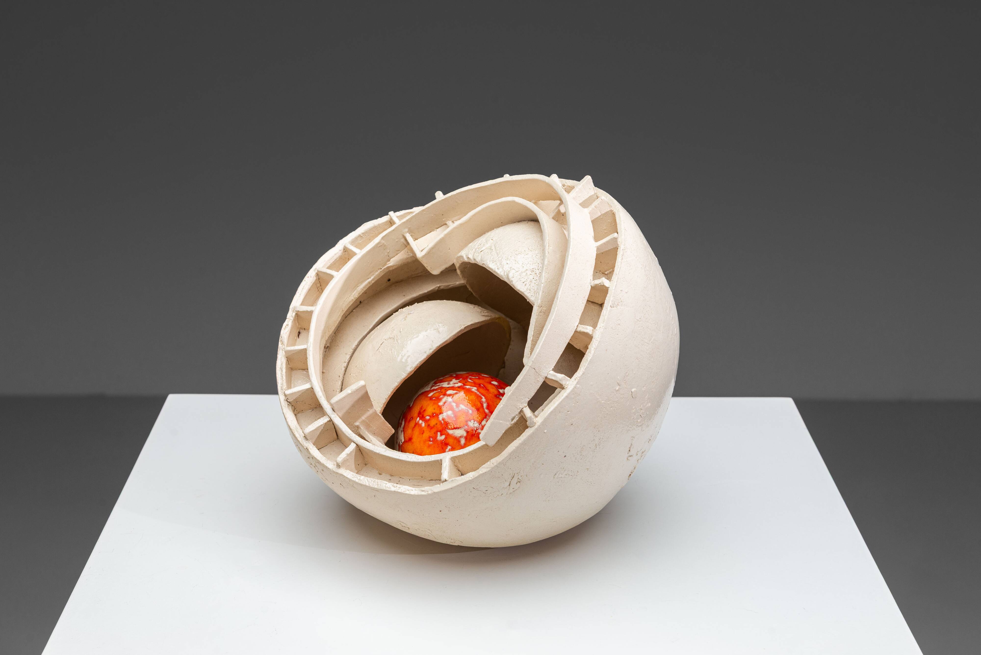 Sculpture en céramique abstraite avec un noyau orange.