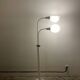 Lampadaire blanc sur pied avec bras rotatifs et abat-jours.