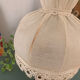 Small vintage wooden turned table lamp with a pleated shade.