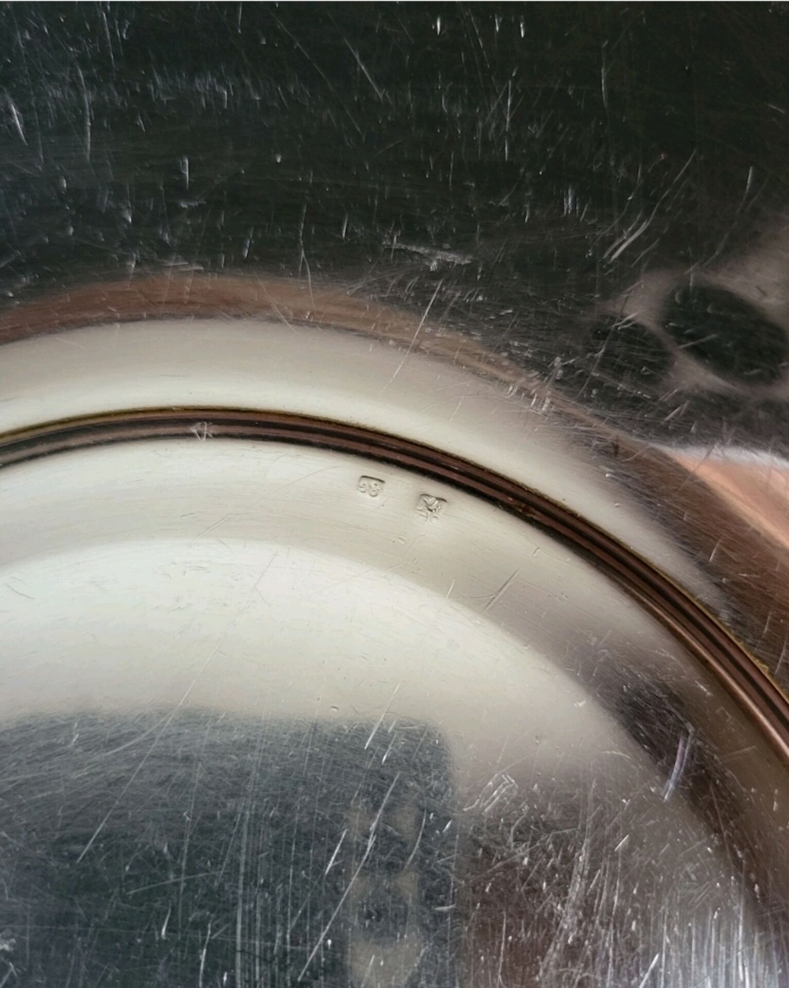 Shallow round metal plate with pearl row decoration.