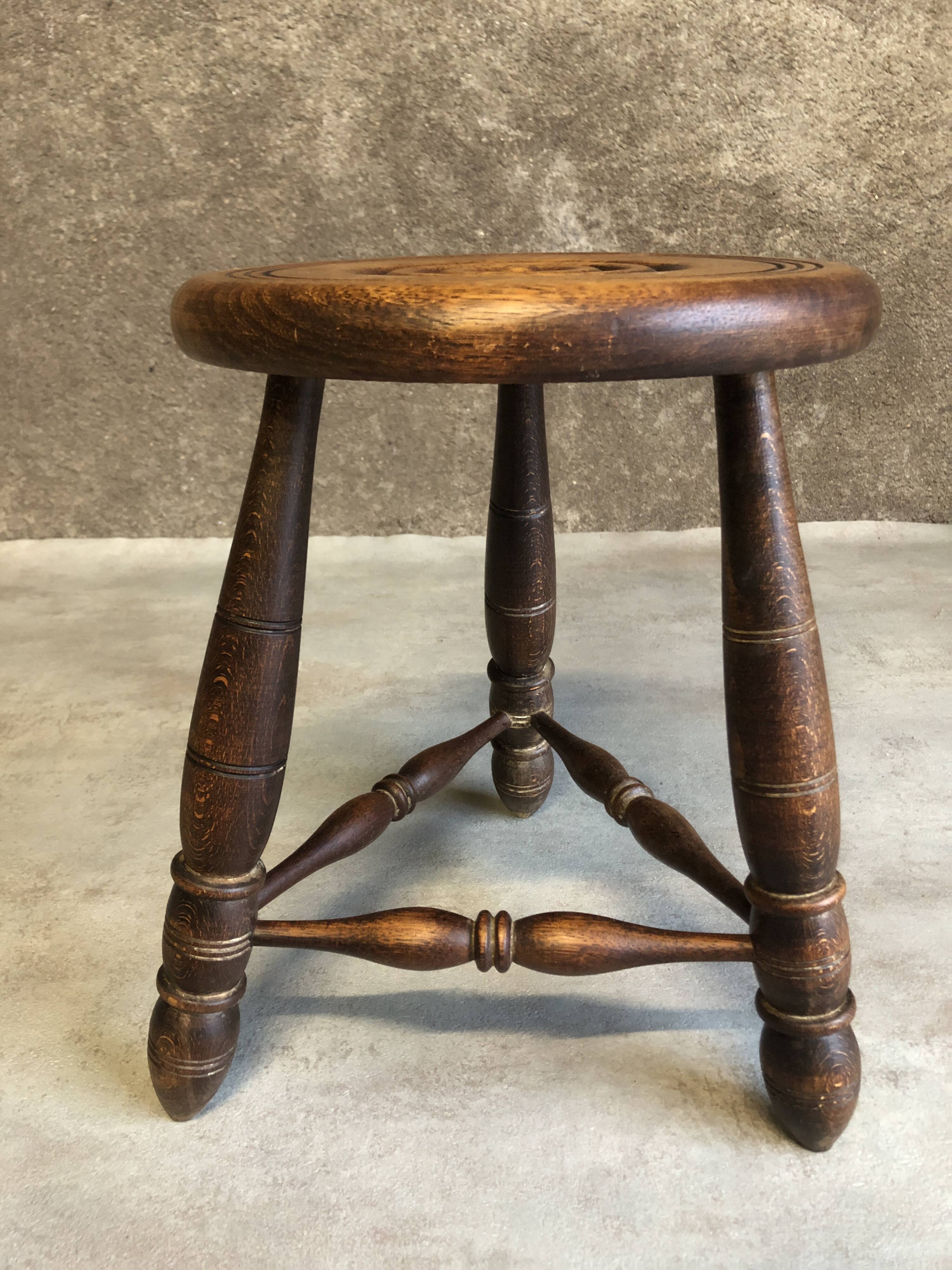 Round tripod stool in dark wood
