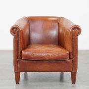 Cognac-colored cow leather club chair finished with decorative nails in English style