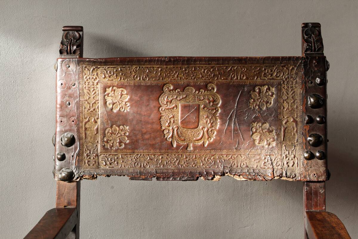 Antique armchair in walnut and studded leather, 17th century
