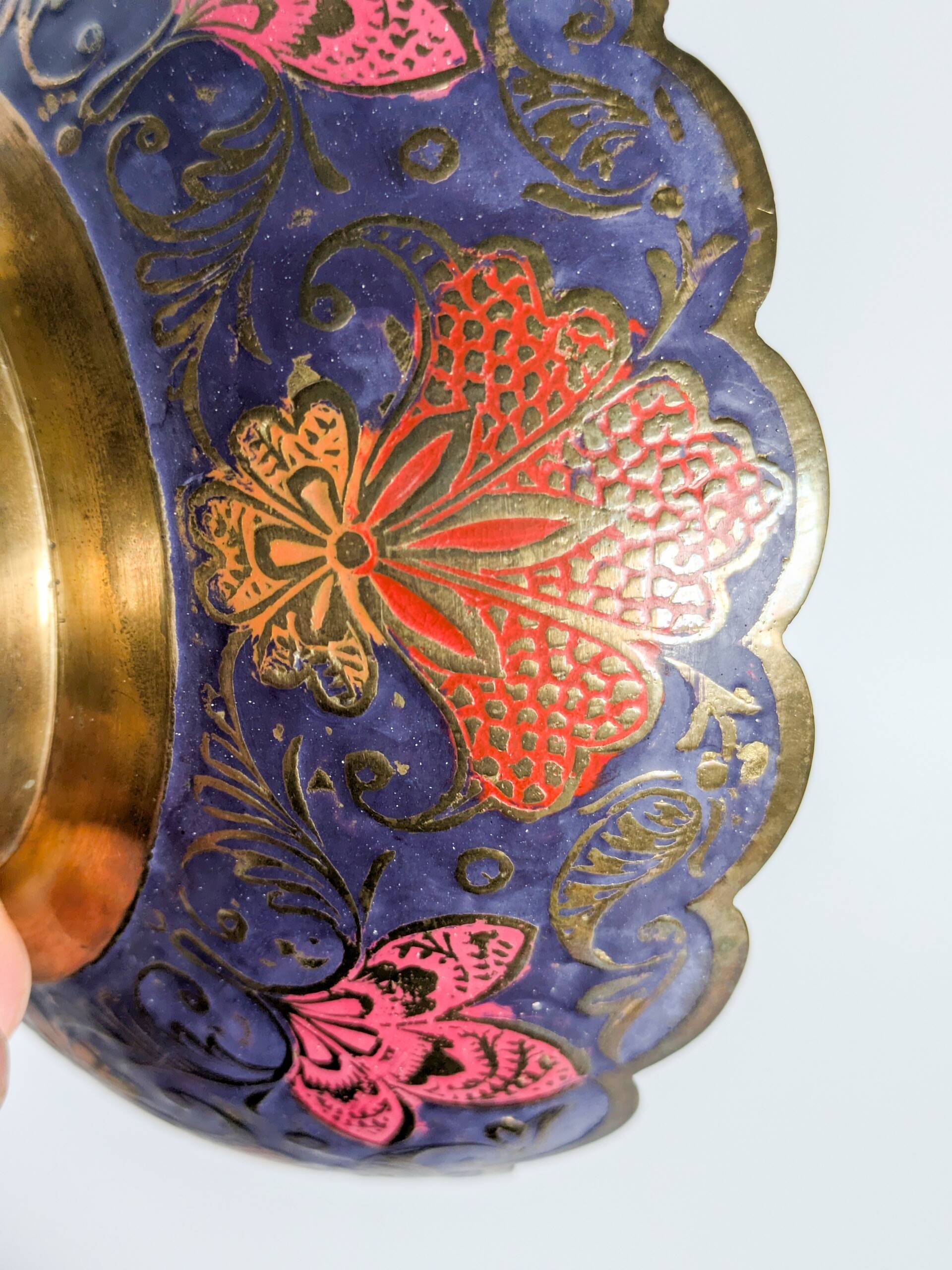 Vintage brass bowl with peacock motif, painted enamel, scalloped edge on a pedestal.