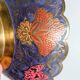 Vintage brass bowl with peacock motif, painted enamel, scalloped edge on a pedestal.