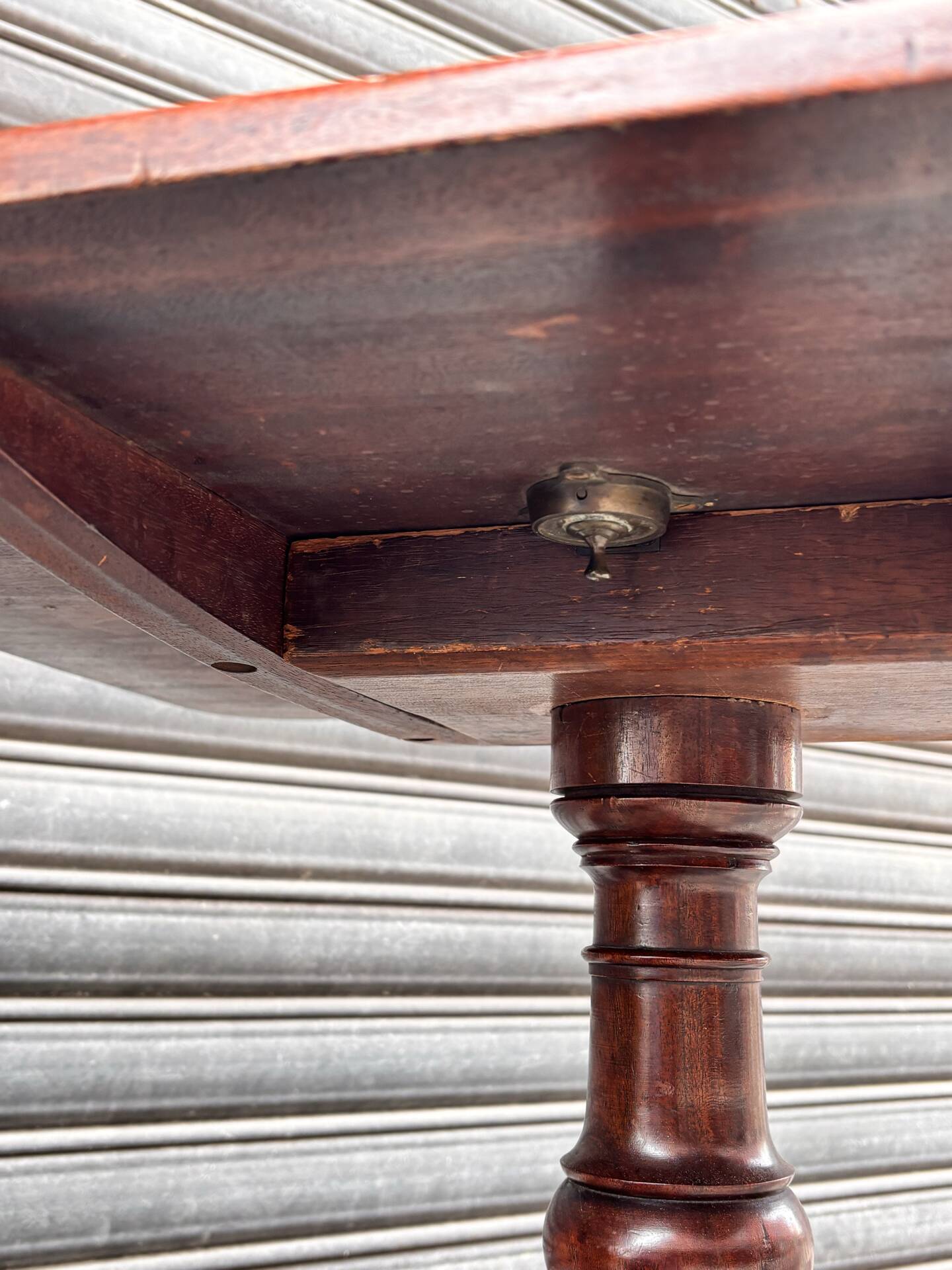 19th-century solid mahogany table with a tilting top and brass mechanism.