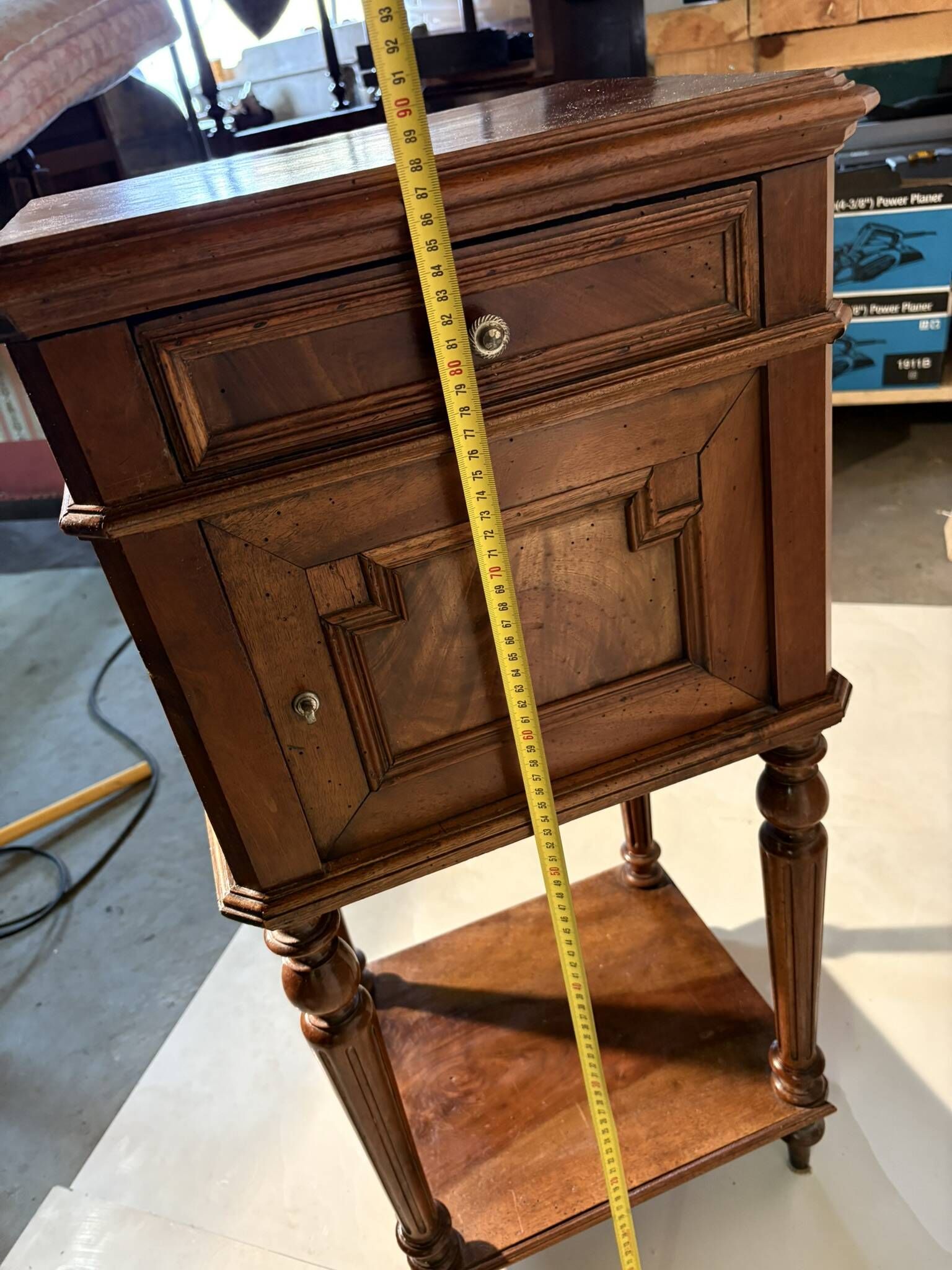 Antique wooden bedside table with turned legs.