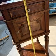 Antique wooden bedside table with turned legs.