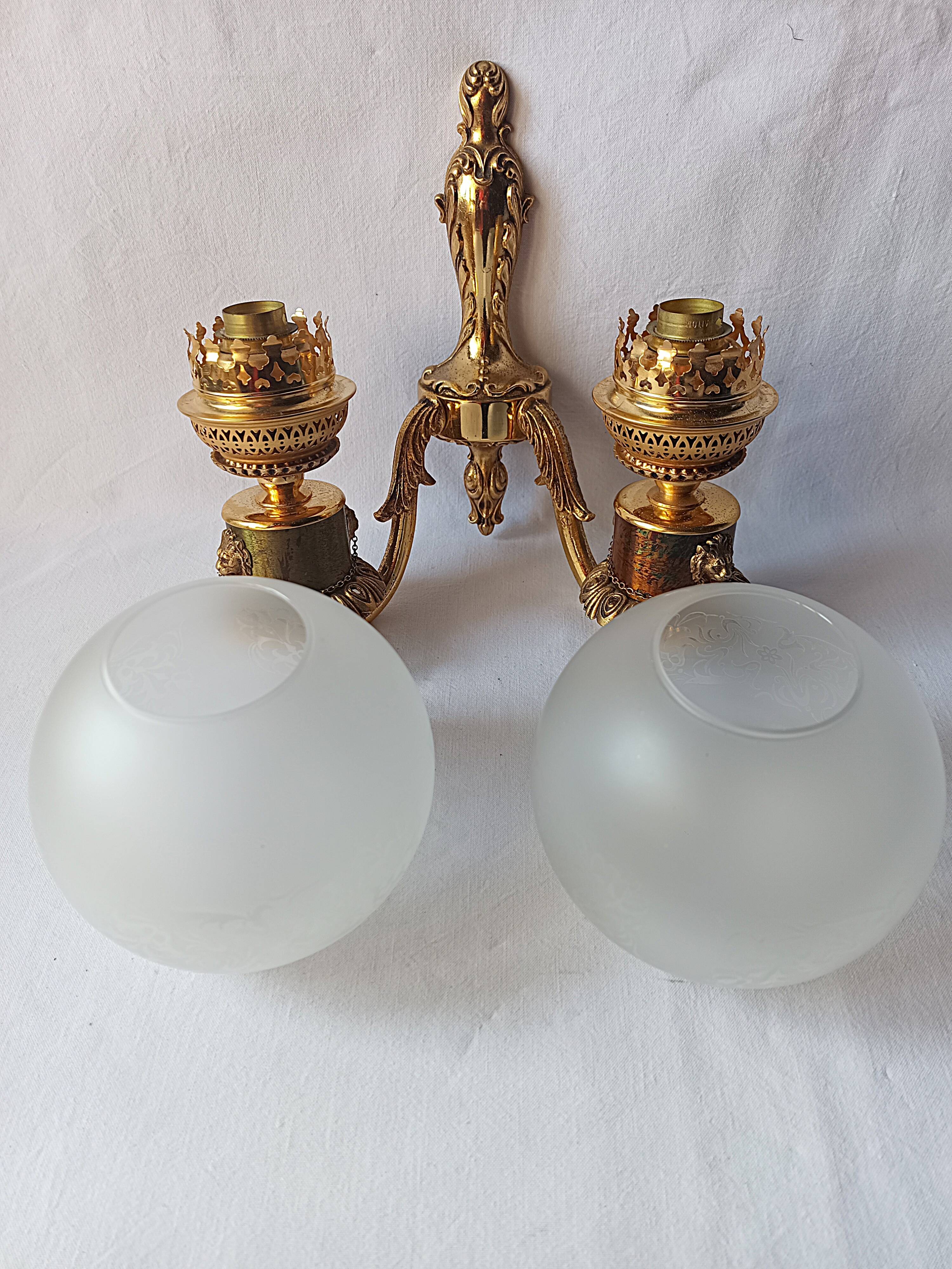 Wall lamp in gilded bronze with a lion's head and engraved globe.