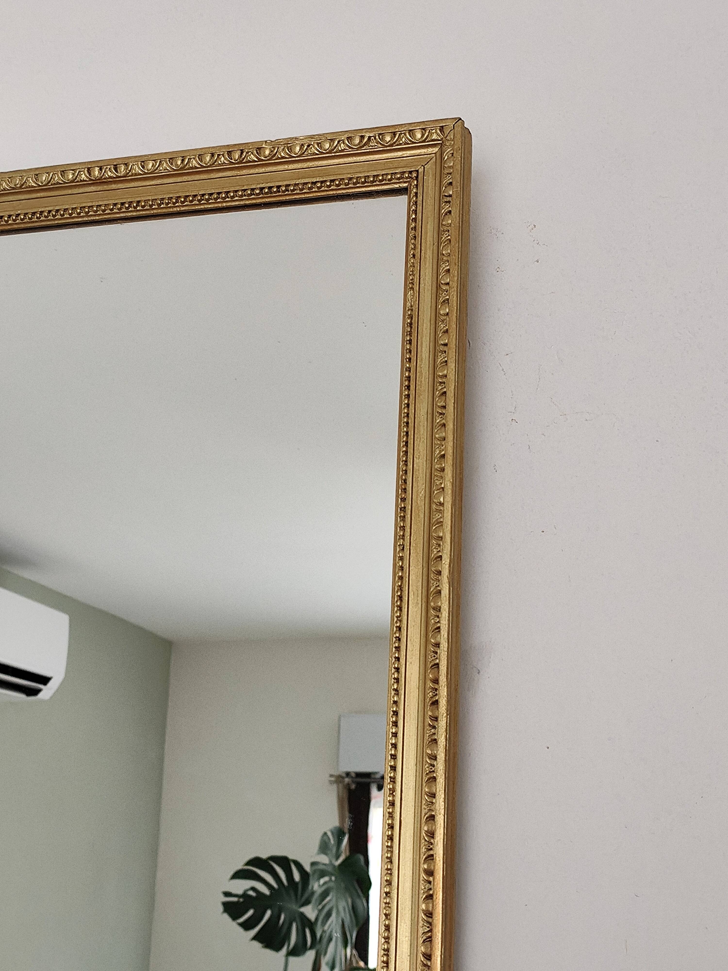 Antique mirror with a gilded frame and beaded border.