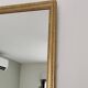 Antique mirror with a gilded frame and beaded border.