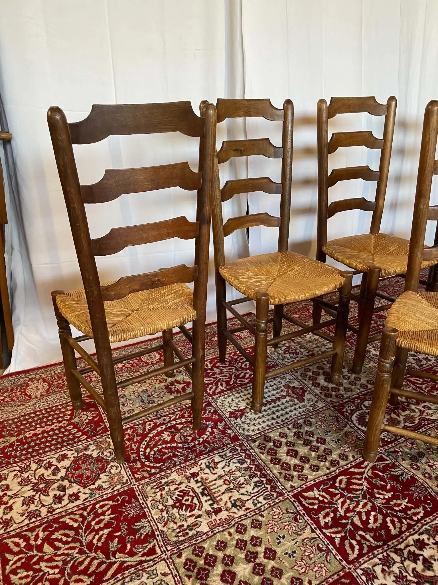 Set of 5 antique solid oak chairs with straw seats.