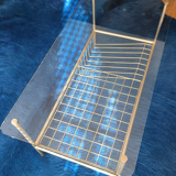 Glass coffee table with gold metal magazine holder