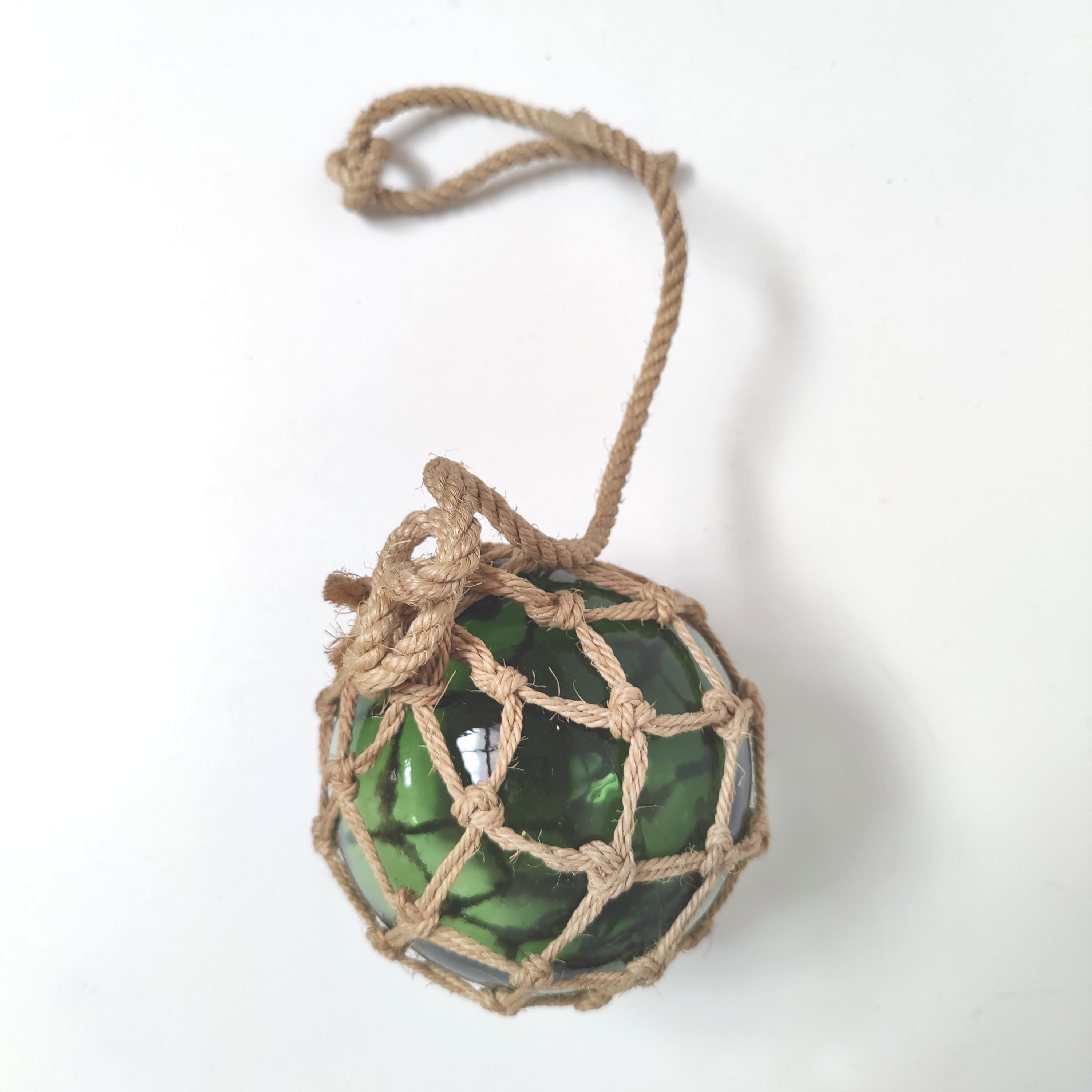 Green ball marine float in glass and rope