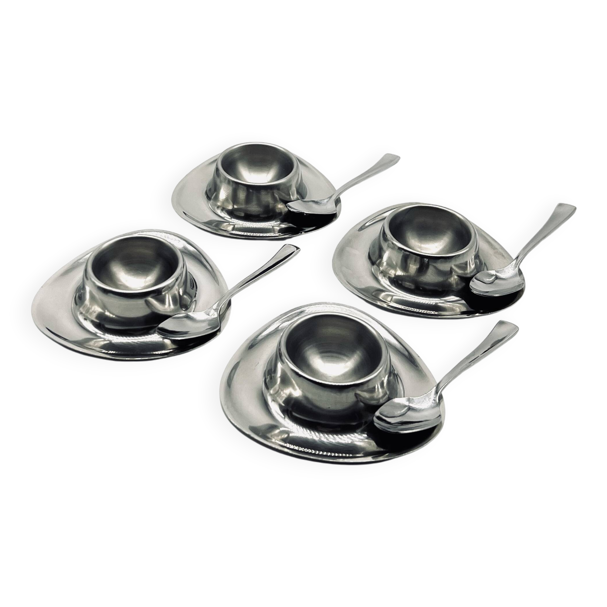 Four stainless steel egg cups and spoons