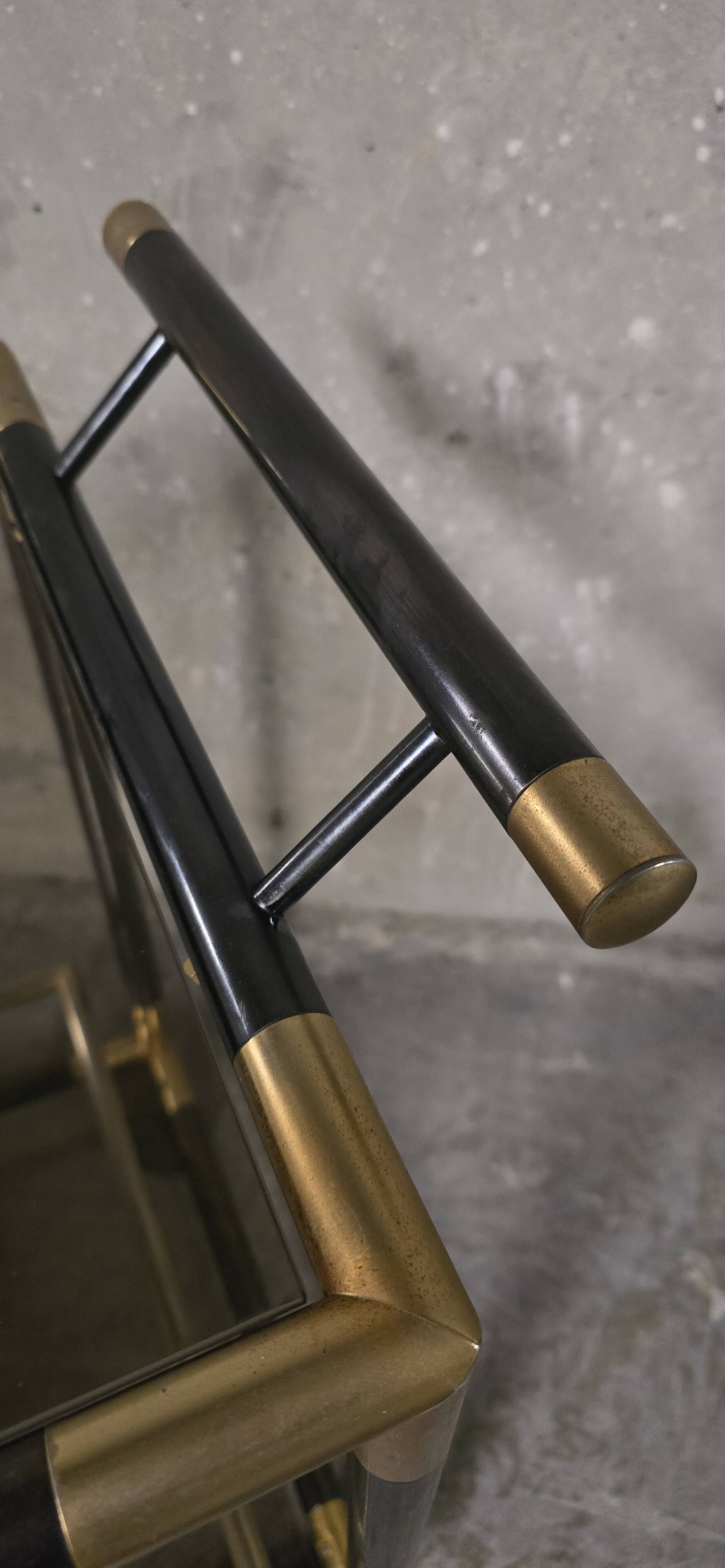 Black metal and brass rolling dessert trolley, smoked glass, 1970s.