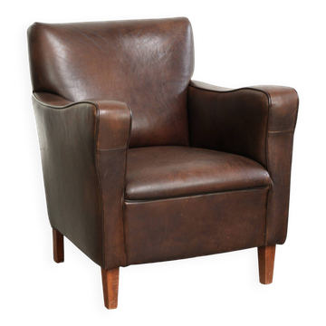 Subtle dark vintage sheepskin armchair with fixed seat cushion and timeless design