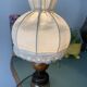 Small vintage wooden turned table lamp with a pleated shade.