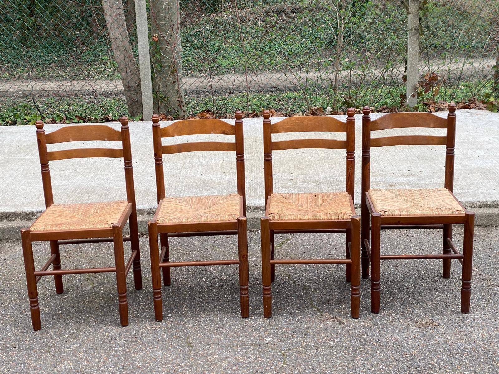 4 dining or kitchen chairs made of solid wood with rush seats.