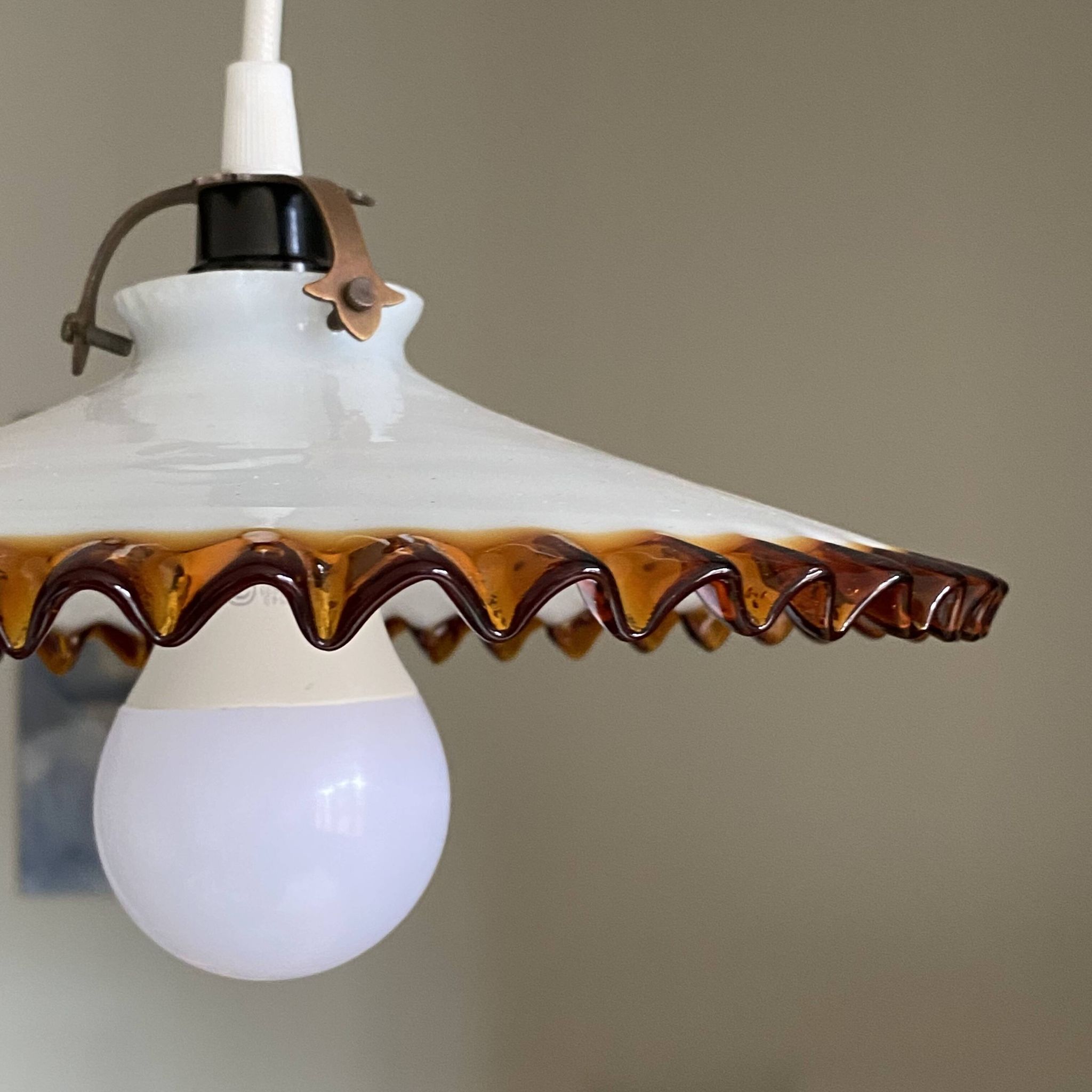 Old pendant light with a white opaline glass shade and a wavy border.